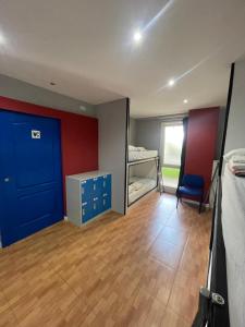 Pokój z niebieskimi drzwiami i łóżkiem w obiekcie Hego Haize Zarautz Hostel w mieście Zarautz