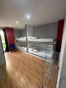 Pokój z 2 łóżkami piętrowymi i niebieskim krzesłem w obiekcie Hego Haize Zarautz Hostel w mieście Zarautz