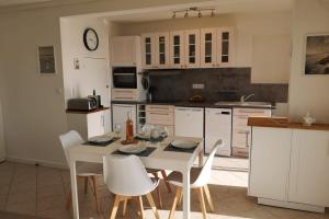 Una cocina con una mesa y sillas en una cocina. en La trouvaille - port et mer grand balcon parking, en Bandol