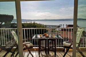 una mesa en un balcón con vistas al agua en La trouvaille - port et mer grand balcon parking, en Bandol