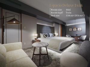 a hotel room with a bed and two chairs at Nagoya Kanko Hotel in Nagoya +158 photos