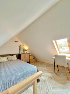 a bedroom with a bed and a desk and a window at Charming Cottage - Sauna - Central Location in Šiauliai