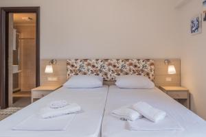 a bedroom with a white bed with towels on it at Grameno Apartments in Kountoura Selino