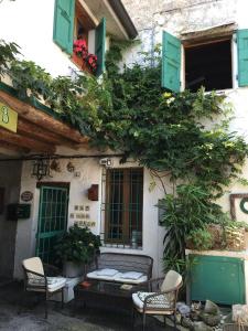 a building with green shuttered windows and a bench at La Casa di Marla in Sirmione