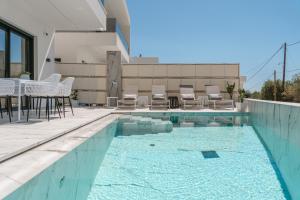 a swimming pool with chairs and a table on a building at Zandore Villas Perdika private Luxury Villas Epirus Villas in Pérdika