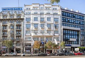 um grande edifício branco com carros estacionados em frente em Zepter Hotel Belgrade, member of Zepter Hotels em Belgrado