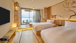 a hotel room with two beds and a flat screen tv at Kumonoue Fuji Hotel Standard room - Mt Fuji view with open-air bath in Fujikawaguchiko
