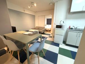 a kitchen and living room with a table and chairs at Stay Hakata in Fukuoka