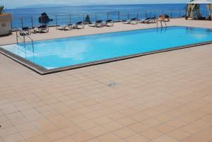 a swimming pool with the ocean in the background at Apartamento do Mar in Funchal