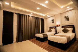 Habitación de hotel con 2 camas y cortinas en Hotel D'Palazzo, en Kohīma 18 fotos más