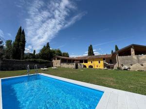 a swimming pool in front of a house at Cascina Monte Tivino in Salò