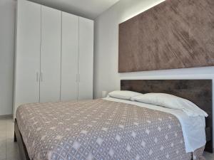 a bedroom with a bed and white cabinets at La Casa di Mimi in Monopoli