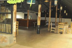 a large room with wooden poles and tables and chairs at Cocopark Hotel in Rwinkwavu +12 photos
