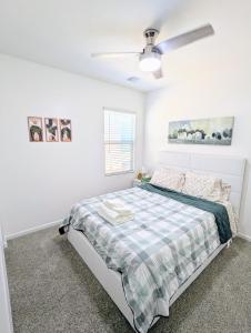 a white bedroom with a bed and a ceiling fan at Spacious 3BR Home - Pool, Playground, EV Station L2, Near Freeway, Free Parking in Tucson +26 photos