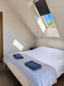 a bedroom with a bed with blue towels on it at #MazuryLove in Giżycko
