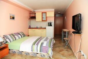 a bedroom with a bed and a small kitchen at Apartments Hari Tisno in Tisno