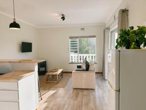 a kitchen and living room with a refrigerator at Leisure Isle Loft Apartment in Knysna