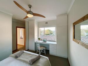 a bedroom with a bed and a desk and a window at Leisure Isle Loft Apartment in Knysna