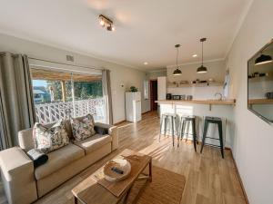 a living room with a couch and a kitchen at Leisure Isle Loft Apartment in Knysna
