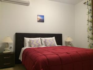 a bedroom with a red bed with a red blanket at Catherine Villas in Maronia +191 photos