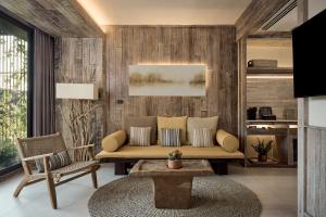 芭东海滩Dinso Resort & Villas Phuket, Vignette Collection by IHG的带沙发和桌子的客厅