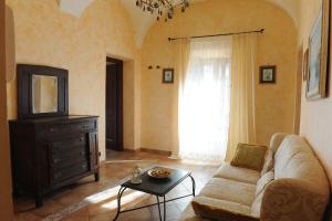 a living room with a couch and a tv at La Dimora Dei Cavalieri in San Polo dei Cavalieri