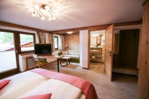 a bedroom with a bed and a desk and a television at Ferienwohnung Alpenecho in Ramsau am Dachstein