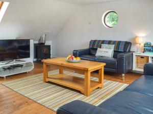 a living room with a couch and a coffee table at The Boathouse in Little Haven