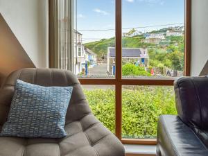 a living room with a couch and a large window at The Boathouse in Little Haven