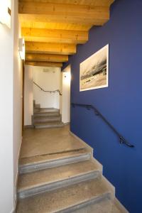 a hallway with blue walls and stairs with a painting at Hotel All'Arco in Trieste