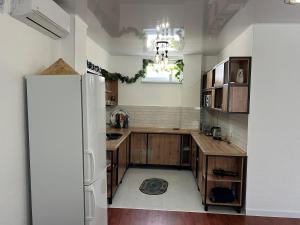 a kitchen with wooden cabinets and a white refrigerator at Домик у моря in Ömirzaq +17 photos