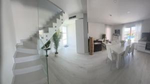 eine weiße Treppe in einem weißen Wohnzimmer mit einem Tisch in der Unterkunft Villa Ocean View2,Vollausstattung,Pool,Meerblick,Top-Lage in Razvala