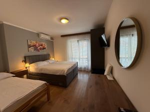 a bedroom with two beds and a mirror at Pansion Katarina Krk in Malinska