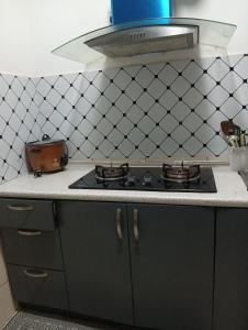 a kitchen with a black stove top in a kitchen at Ereens homestay 3 Palas horizon in Cameron Highlands
