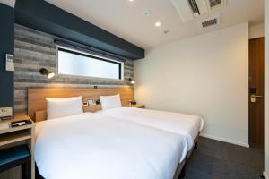 a hotel room with two beds and a window at HOTEL TABARD TOKYO in Tokyo