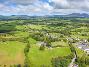 una vista aérea de un pequeño pueblo en un campo verde en Seaborne Cottage - Pwlheli, en Pwllheli