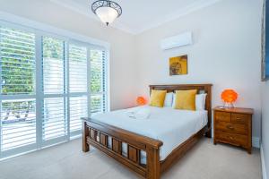 a bedroom with a bed and a large window at Penguin by the Bay in Safety Bay