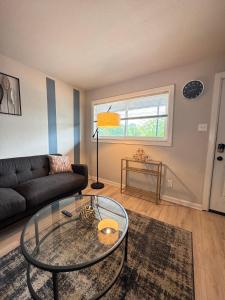 a living room with a couch and a glass table at 1 STATE FAIR l DT Dallas l FIFA READY l Staycation 1Bd1Ba in Dallas