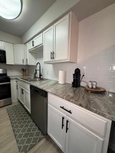 a kitchen with white cabinets and a sink at 1 STATE FAIR l DT Dallas l FIFA READY l Staycation 1Bd1Ba in Dallas +12 photos