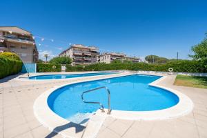 a large swimming pool with blue water at Vistas al mar Torredembarra in Torredembarra