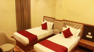 a hotel room with two beds and a chair at Achyutam By IKA Hotels in Bhuteshwar