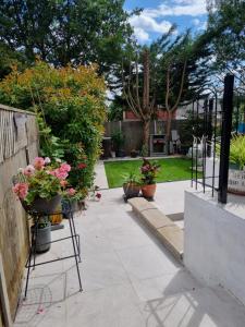 einen Garten mit Topfpflanzen auf einem Gehweg in der Unterkunft Modern self contain studio Own Private Access in Finchley