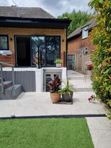 eine Terrasse mit Topfpflanzen vor einem Haus in der Unterkunft Modern self contain studio Own Private Access in Finchley