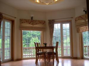 a dining room with windows and a table and chairs at Happy Dream Pension in Pyeongchang