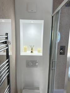 a white bathroom with a shower and a sink at Flat in London Bridge in Moffat