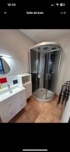 a bathroom with a shower and a sink and a mirror at Chez Titi in Saint Lo