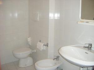 a white bathroom with a toilet and a sink at Locanda La Rotonda in Montale