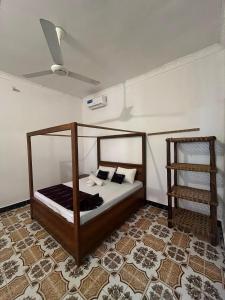 a bedroom with a bed and a ceiling fan at Reef Nungwi House in Nungwi