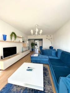- un salon avec un canapé bleu et une table blanche dans l'établissement Grand appartement refait à neuf belle vue mer, à Bandol