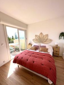 une chambre avec un grand lit rouge avec une grande fleur sur le mur dans l'établissement Grand appartement refait à neuf belle vue mer, à Bandol